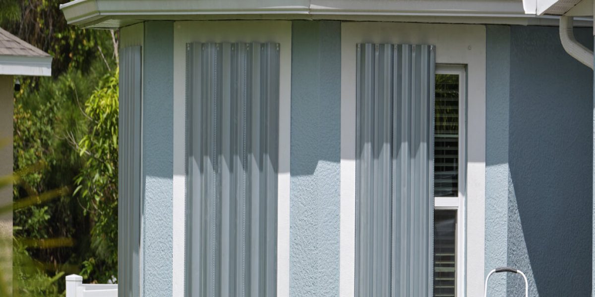 Boarded up windows with steel storm shutters for hurricane protection of residential house. Protective measures before natural disaster in Florida.